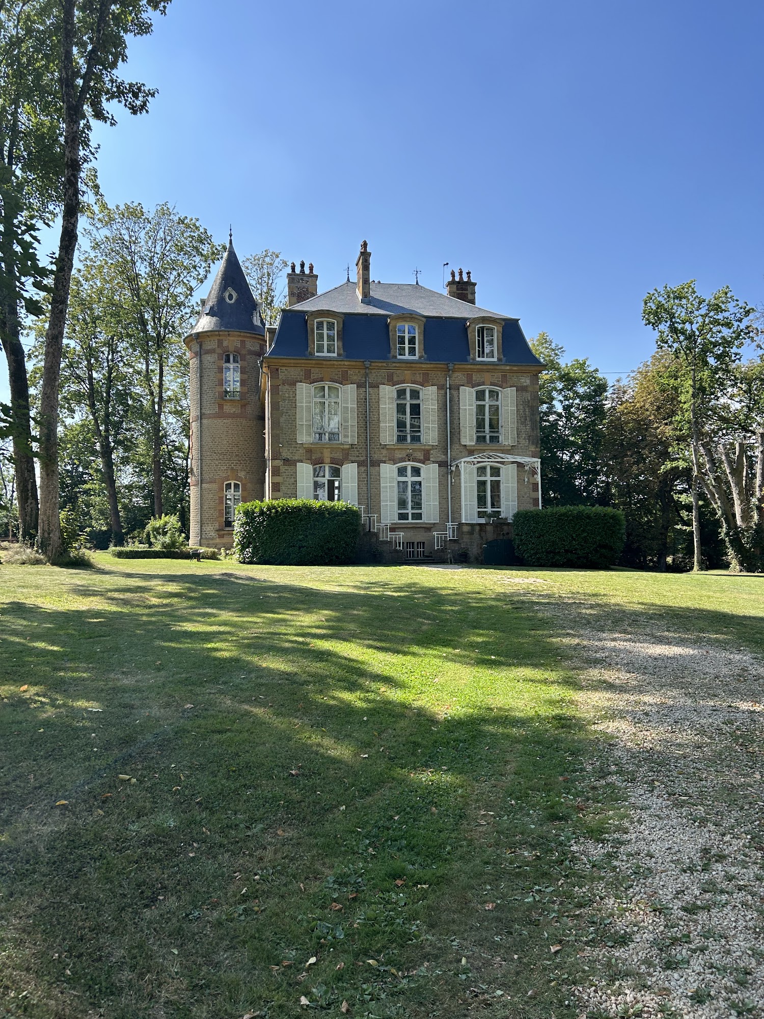 Château Guillermo in de Franse Ardennen, een historisch kasteel omringd door bomen en een groen park.
